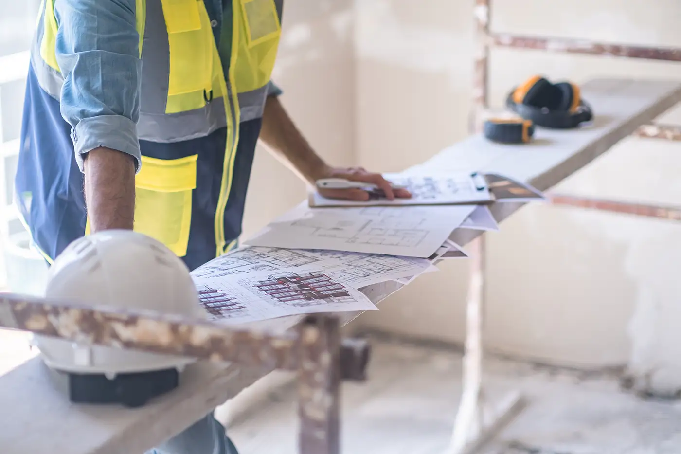 Tecnico in cantiere guarda il progetto di ristrutturazione