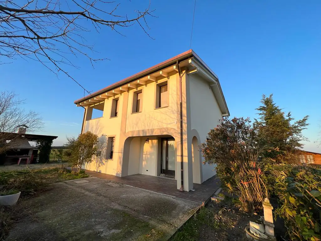 Esterni di una casa color crema e cielo azzurro a Bologna