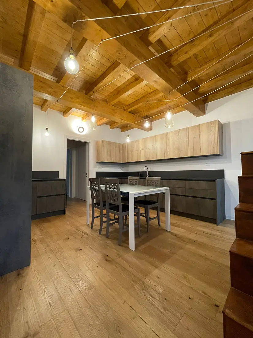 Ristrutturazione di una cucina in legno con tavolo bianco